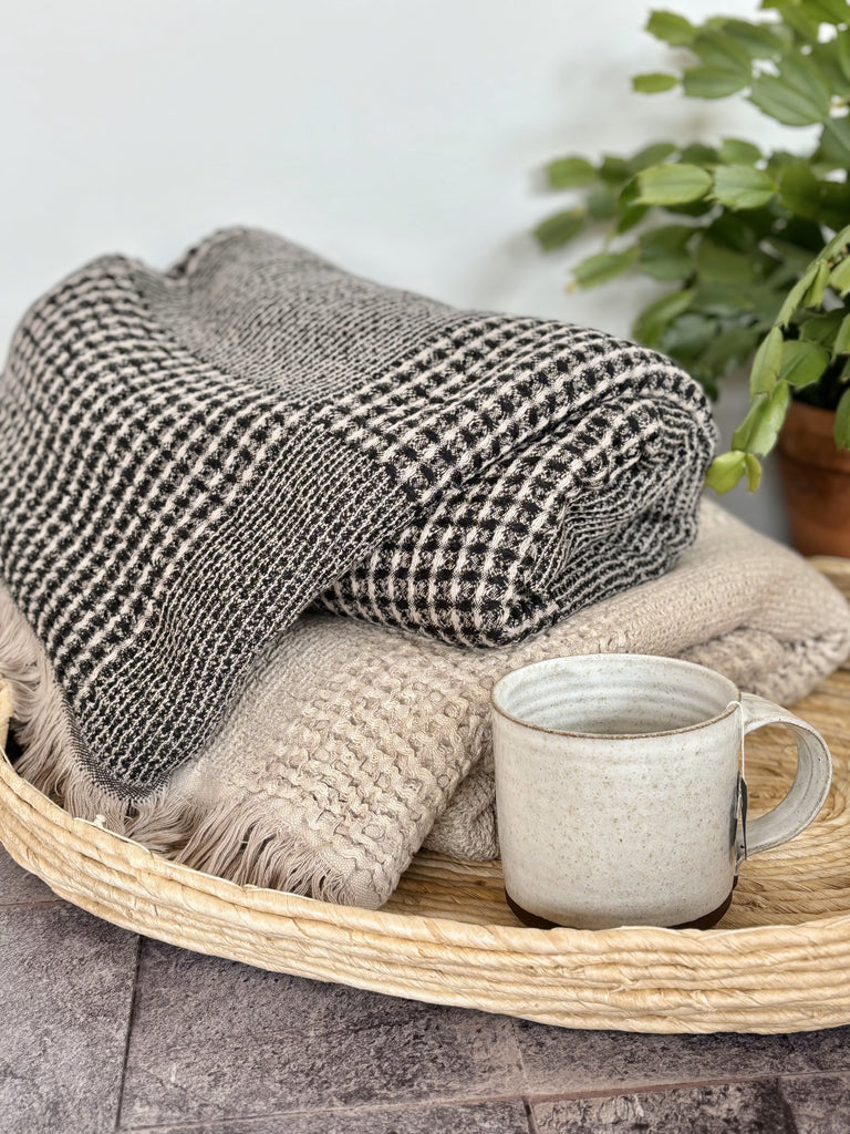 Anza Duello Waffle Throws with a cup of hot tea in woven tray