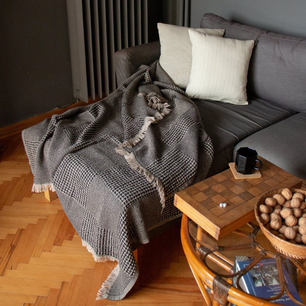 Anza Black Duello Waffle Throw laid flat on sofa