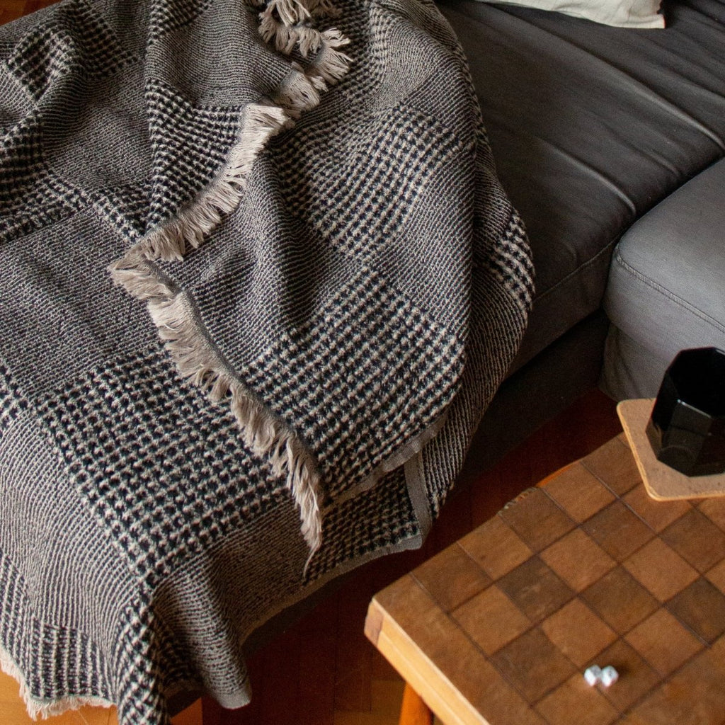 Anza Black Duello Waffle Throw laid flat on sofa