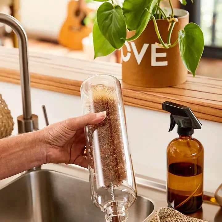 Using an Eco Max Extra Large Bottle Brush to clean a clear bottle