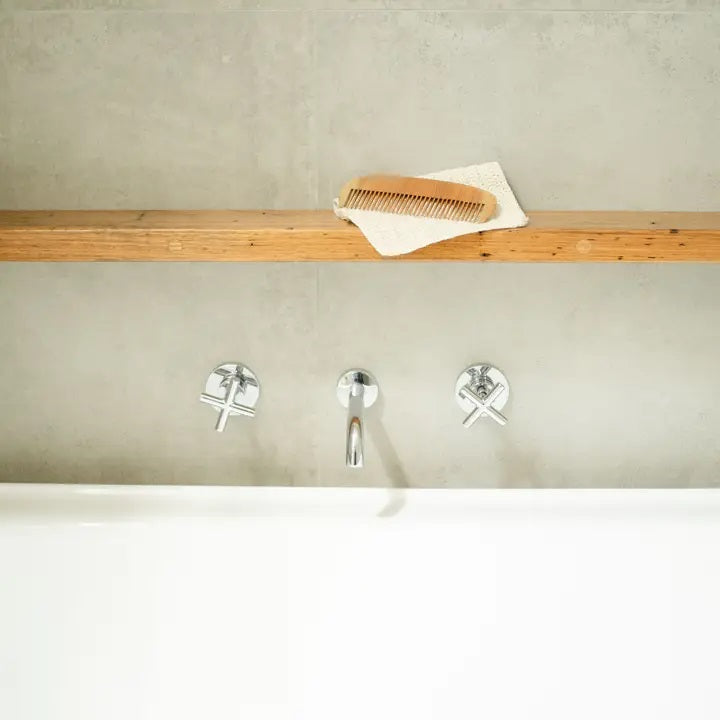 Eco Max Neem Wood Comb on a bench above the bathtub