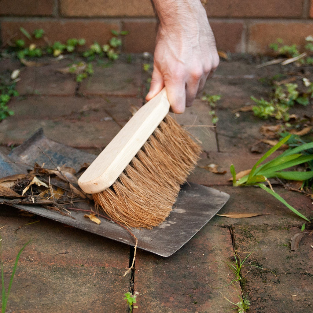 Using an Eco Max Dust Brush to sweep leaves
