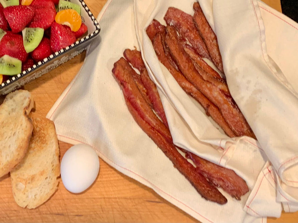 Patting off excess grease from bacon using Handecloth Reusable Grease Absorbers 
