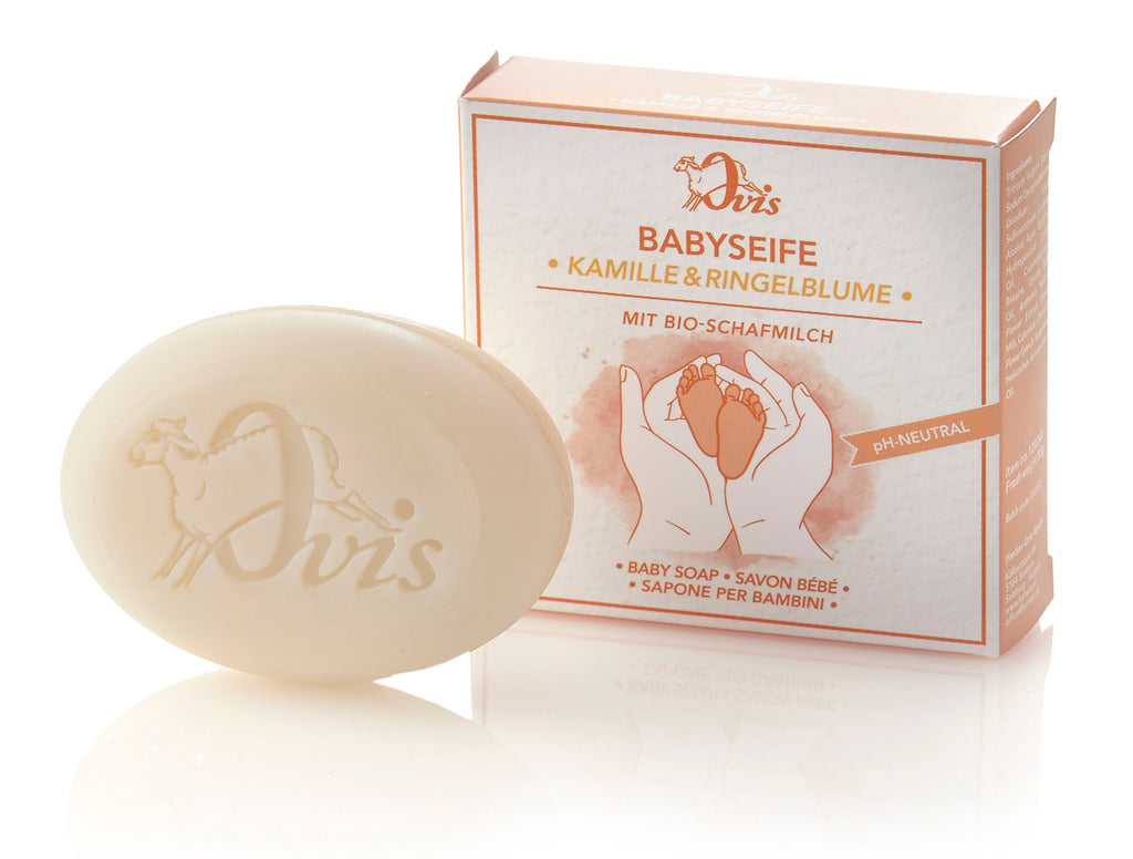 Oval soap with embossed sheep and "Ovis," next to its box featuring baby care illustration and text.