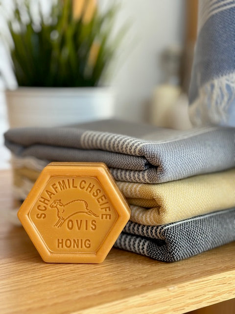 Ovis Hexagonal Honey Soap with a stack of Anza Amber Turkish Hand Towel