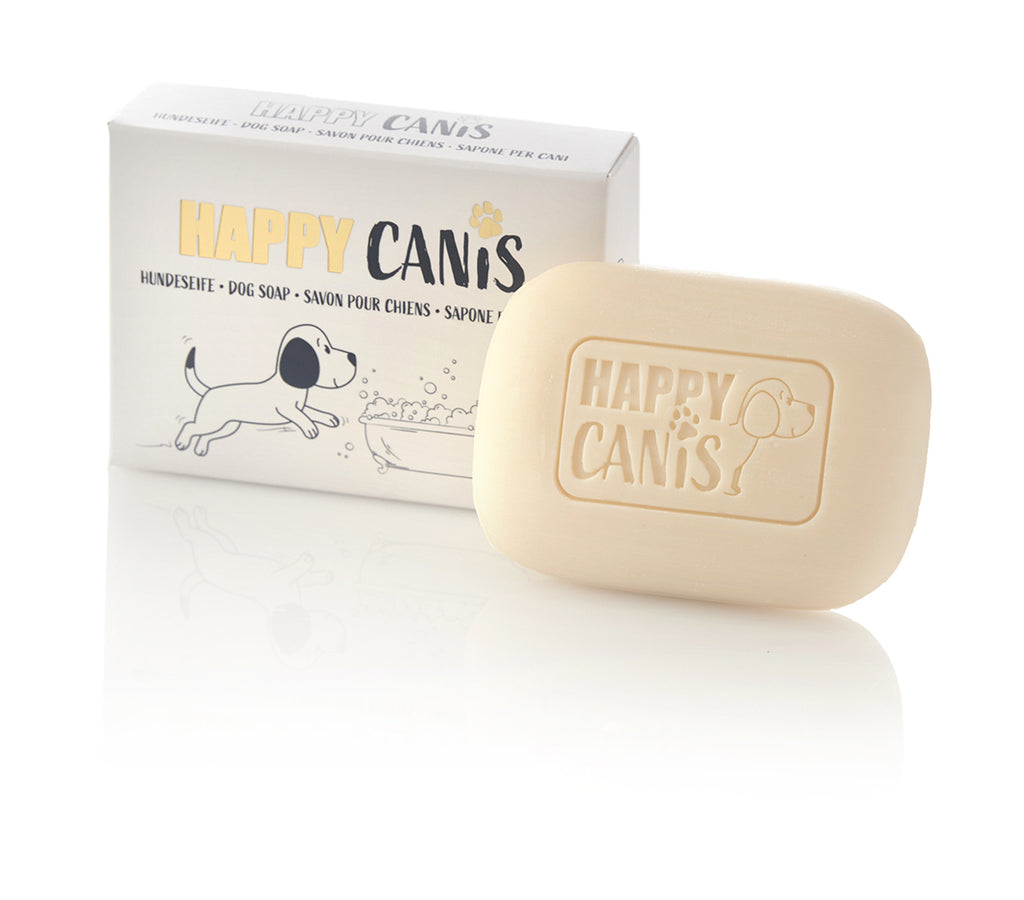 A "HAPPY CANIS" dog soap bar and its packaging with a cartoon dog illustration.