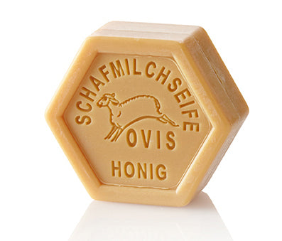 Hexagonal honey-colored soap with embossed design and text.