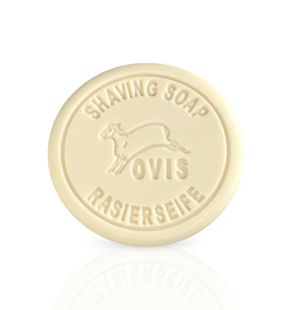 A round, cream-colored shaving soap embossed with a sheep and text.