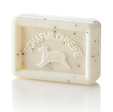 Rectangular creamy, speckled soap bar with a sheep and "SCHAFMILCHSEIFE" embossed on it.