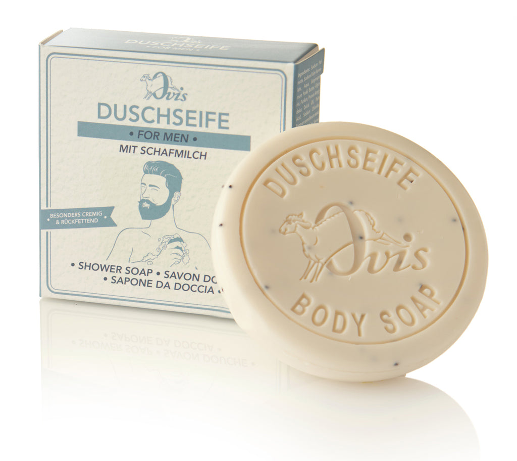 Round cream-colored soap with embossed text and matching blue-toned packaging.