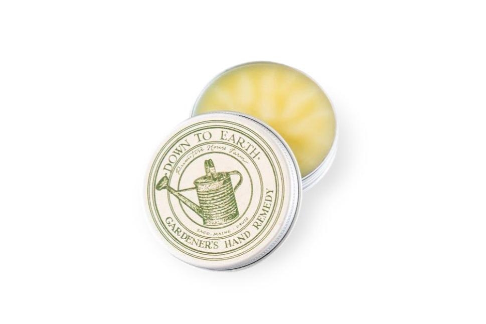 Open tin of "Gardener's Hand Remedy" balm with a watering can illustration on the lid. 