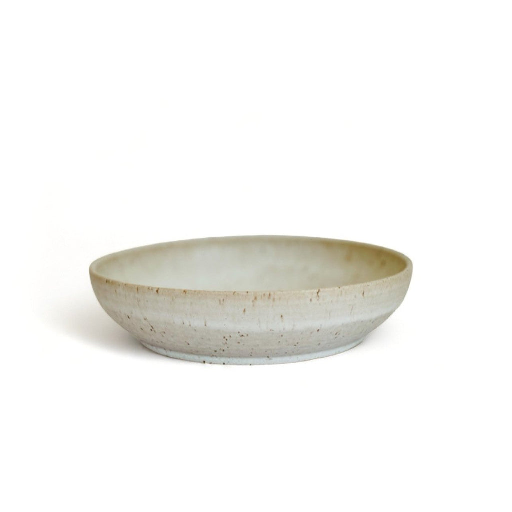 A beige speckled ceramic pasta bowl.