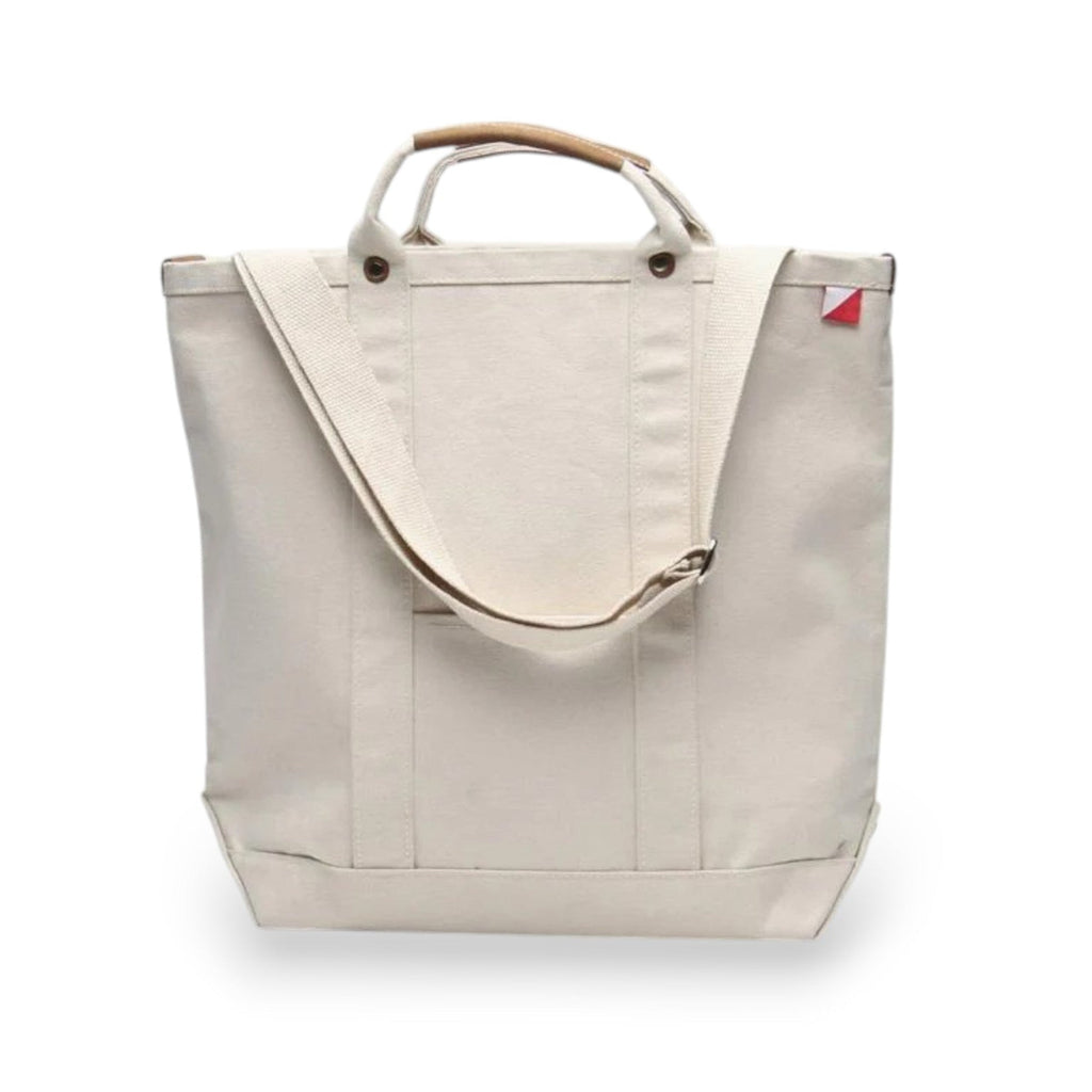 ShoreBags Natural Cargo Canvas Travel Tote bag with brown leather handles and an adjustable shoulder strap, featuring a white & red tag.