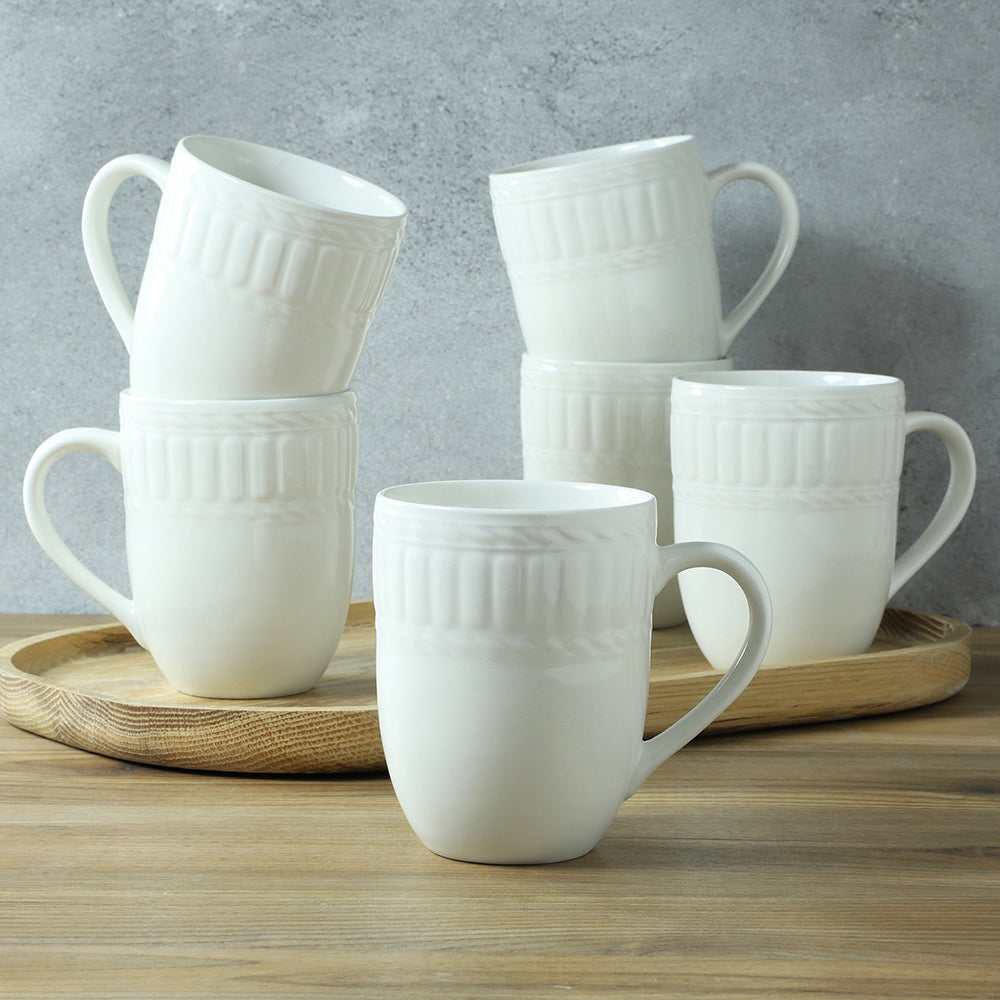 Six white ceramic mugs on a wooden tray with a textured gray background.